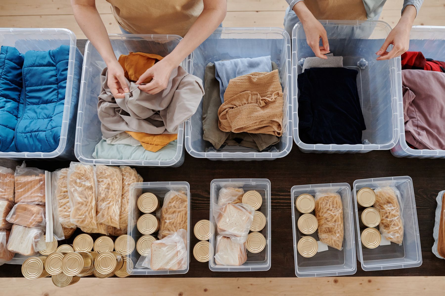 Volunteers sorting clothes and groceries into bins
