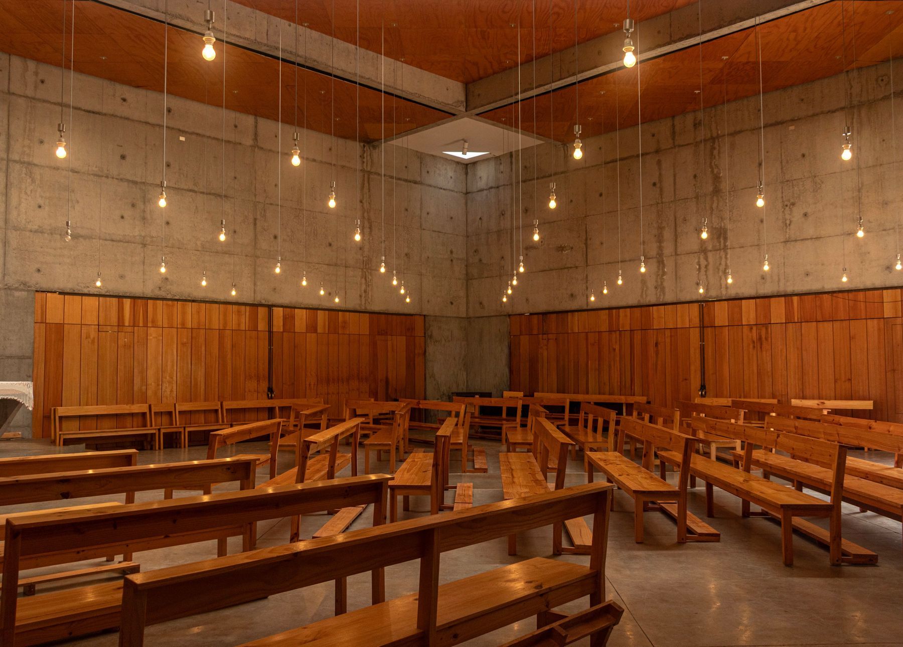 A wooden hall with hanging lights set for Sunday